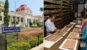 A split image showcasing the Oriental Research Institute in Mysore. On the left, a heritage-style yellow building with a red central dome stands under a clear blue sky behind an entrance sign. On the right, researchers inside an archive room examine ancient palm-leaf manuscripts laid out on a table next to rows of storage shelves.