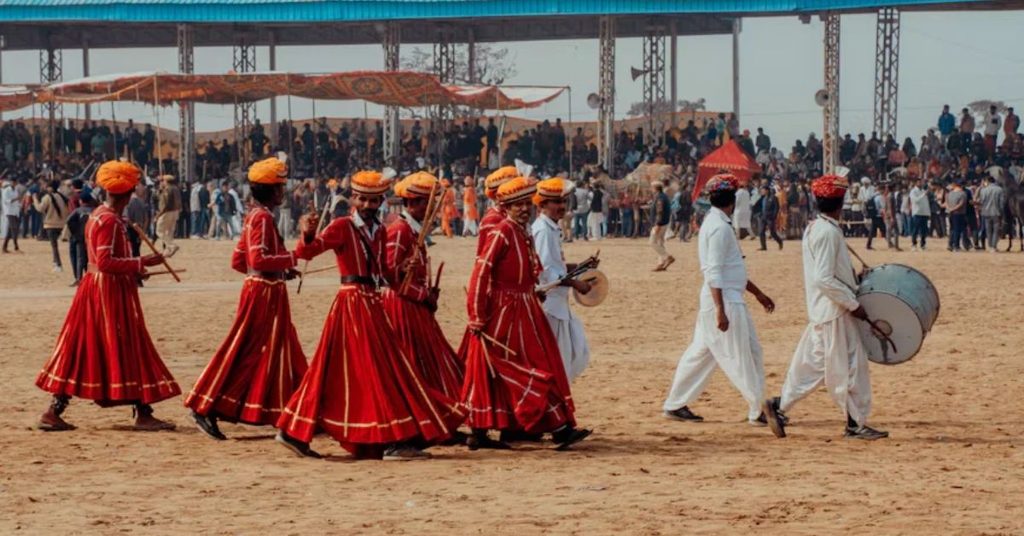 A Group of People Walking Across a Dirt Field, Pushkar, Rajasthan, India