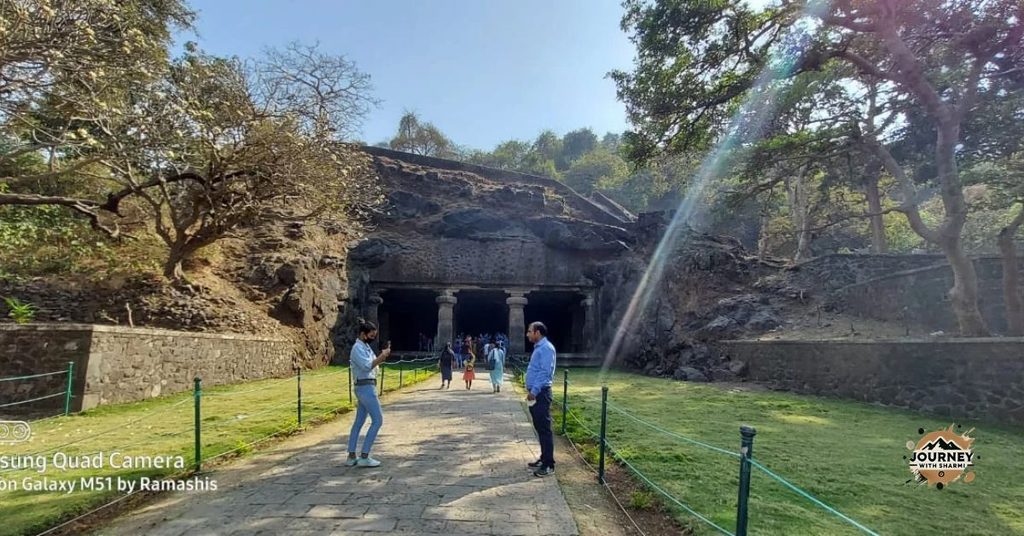 Approaching the Pillared Facade of the Historic Caves Nestled Among the Green Hillside.
